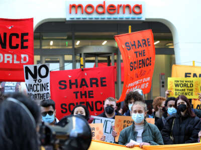 Demonstrators listen to a speaker during a protest in front of Moderna headquarters in Cambridge, Massachusetts, on April 28, 2022.