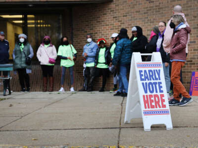 People wait in line outside a polling place at the start of early voting on October 25, 2022, in Milwaukee, Wisconsin.