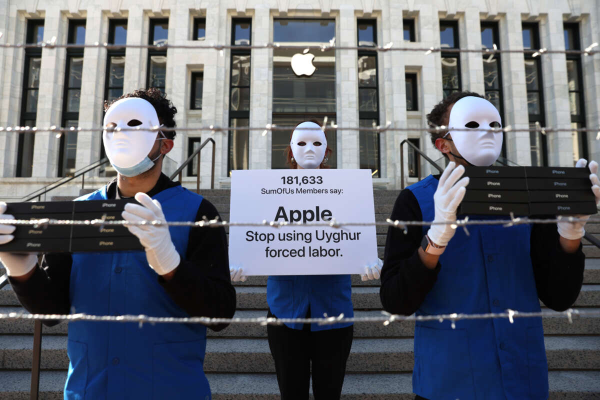Activists with the group SumOfUs wear costumes depicting Uyghurs in a mock forced labor camp as they stage a protest outside of an Apple store on March 4, 2022, in Washington, D.C.