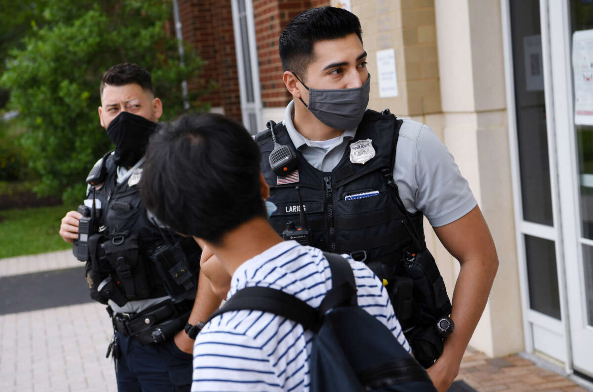 Alexandria Police Department school resource officers talk to a student at T.C. Williams High School on June 9, 2021, in Alexandria, Virginia.