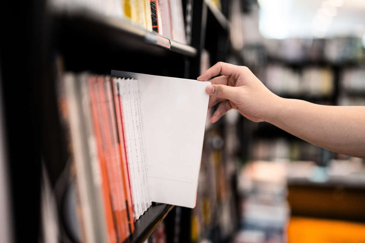 Hand oulls out book at library