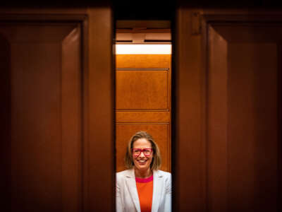 Sen. Kyrsten Sinema smiles while talking to reporters after leaving the Senate chamber on Capitol Hill on November 16, 2022, in Washington, D.C.