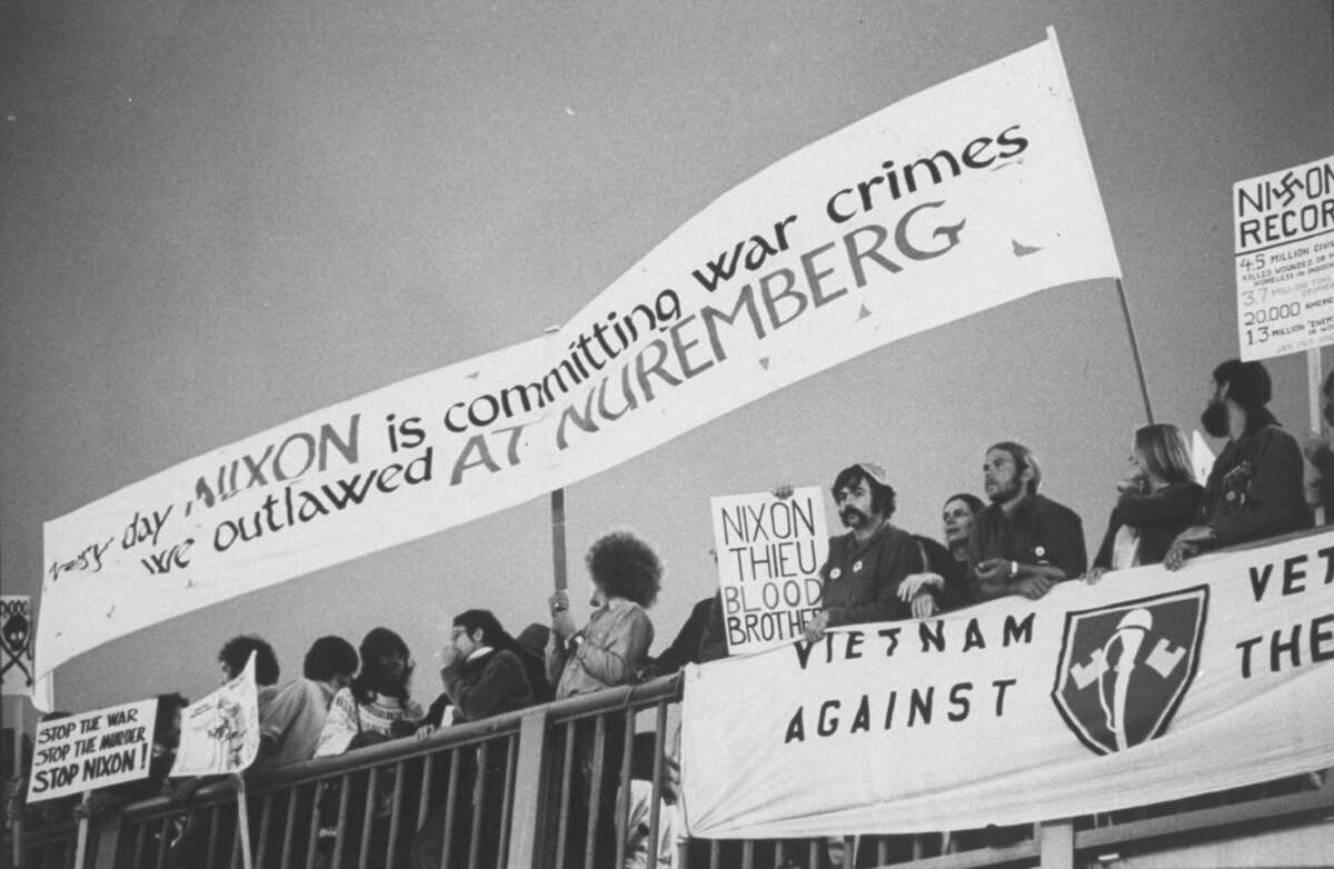 Antiwar demonstrators, including some Vietnam Veterans Against the War, hold banners denouncing the general war effort and President Richard Nixon specifically, outside a hotel where Nixon is holding a fundraising dinner on September 27, 1972.