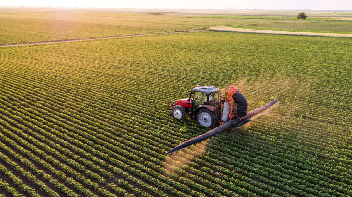 Tractor spraying pesticides in a field
