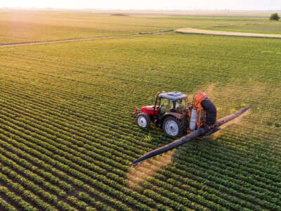 Tractor spraying pesticides in a field