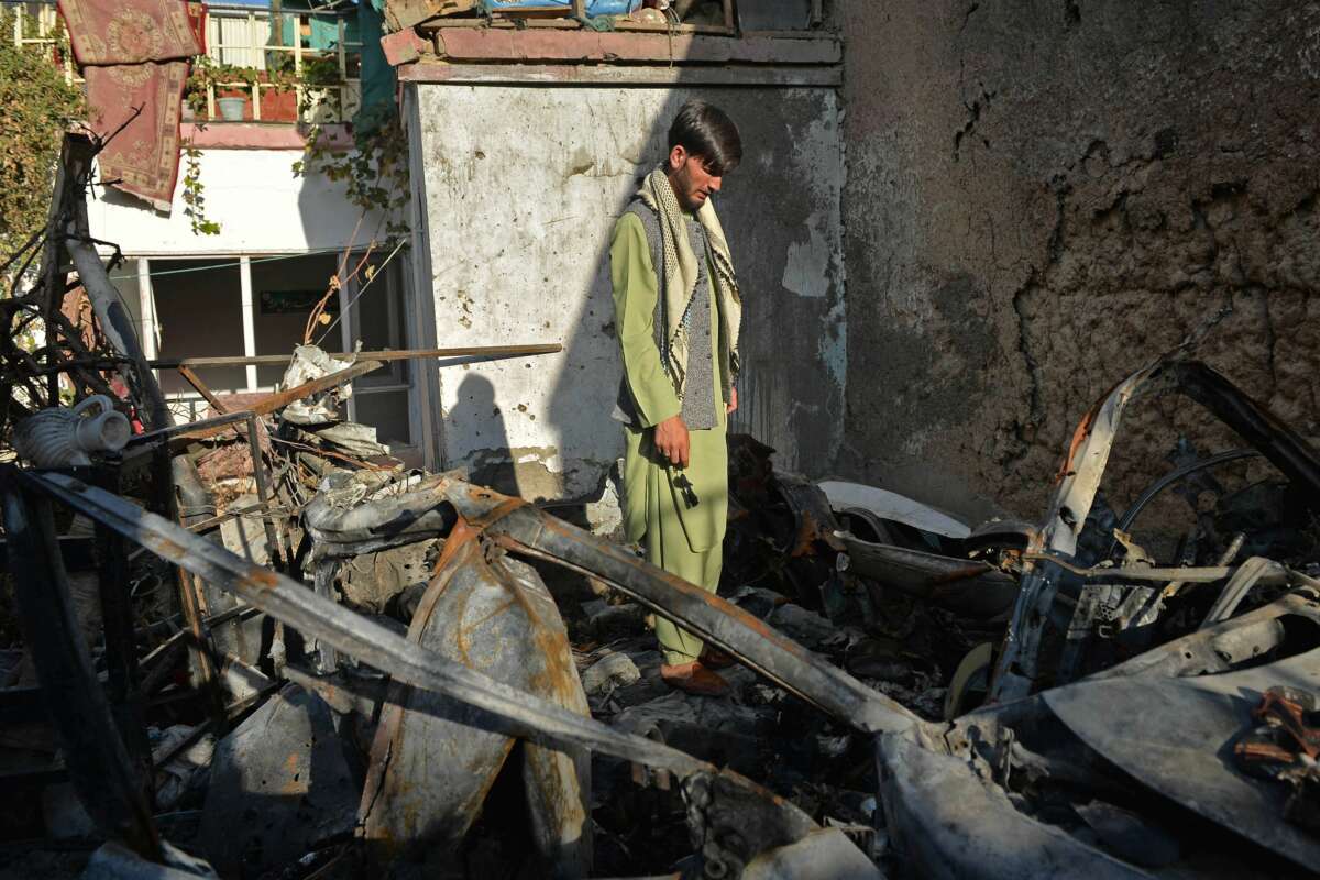 A neighbor of Ezmarai Ahmadi stands amid the debris of Ahmadi's house, which was damaged in an August 29 U.S. drone strike that killed 10 members of the Ahmadi family in the Kwaja Burga neighborhood of Kabul, on September 18, 2021.