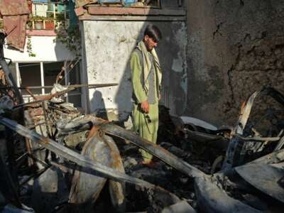 A neighbor of Ezmarai Ahmadi stands amid the debris of Ahmadi's house, which was damaged in an August 29 U.S. drone strike that killed 10 members of the Ahmadi family in the Kwaja Burga neighborhood of Kabul, on September 18, 2021.