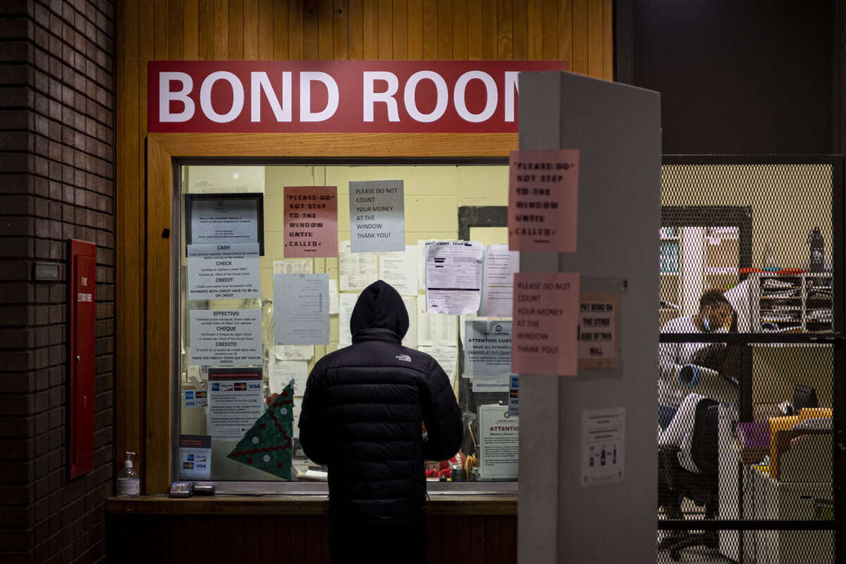 A man pays cash bail in the bond office to secure his brother's release on December 21, 2022 at Division 5 of Cook County Jail in Chicago, Illinois.