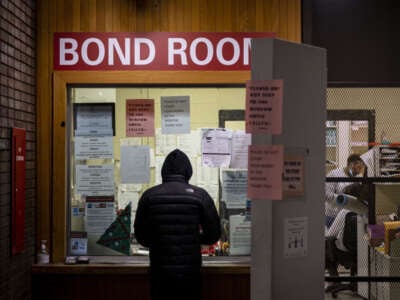 A man pays cash bail in the bond office to secure his brother's release on December 21, 2022 at Division 5 of Cook County Jail in Chicago, Illinois.