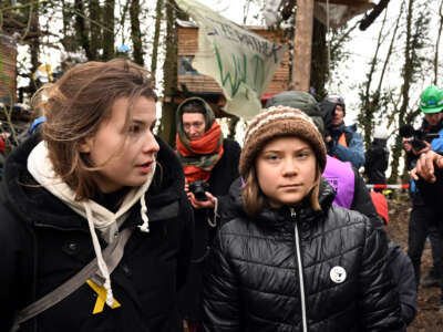 Climate activists Luisa Neubauer (L) and Greta Thunberg (R) stand on the third day of the eviction in the lignite hamlet of Lützerath occupied by climate activists in North Rhine-Westphalia, Germany, on January 13, 2023.