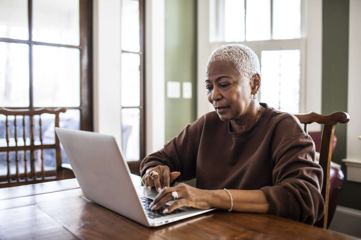 Black senior woman using a laptop