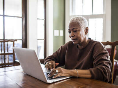 Black senior woman using a laptop