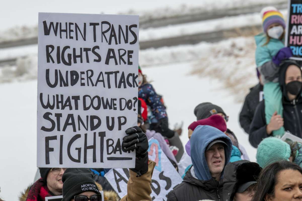 A protester holds a sign reading "When trans rights are under attack what do we do? Stand up fight back." Minnesotans hold a rally at the state capitol to support trans kids in Minnesota, Texas, and around the country on March 6, 2022, in St Paul, Minnesota.