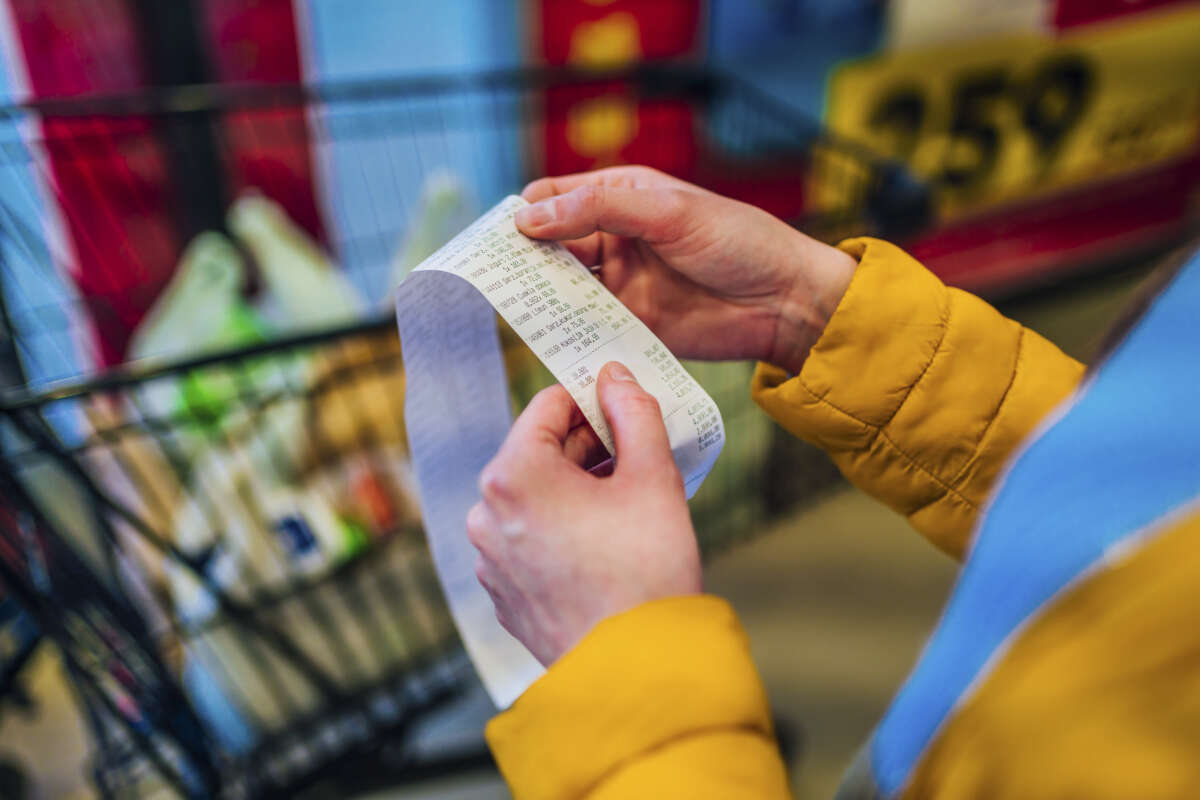 Person checking receipt after paying for groceries