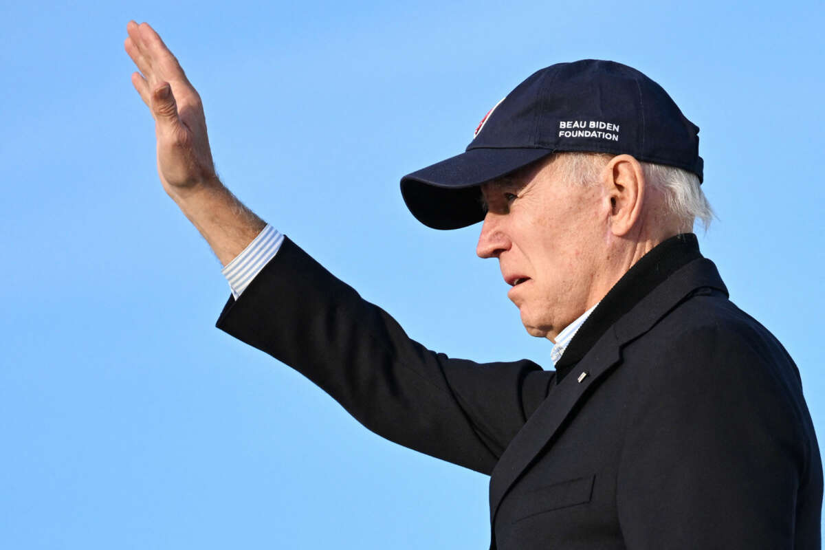 Joe Biden waves to supporters out of frame while wearing a baseball cap
