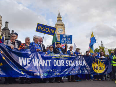 People protest in front of Big Ben, behind a banner requesting their star on the EU flag back
