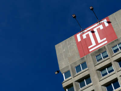 A view of a building on the Temple University campus, set against a cloudless sky