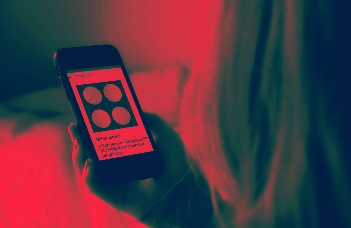 In this photo illustration, a person looks at an Abortion Pill (RU-486) for unintended pregnancy from Mifepristone displayed on a smartphone