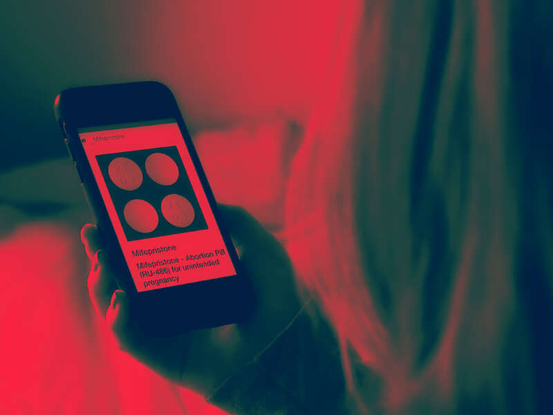 In this photo illustration, a person looks at an Abortion Pill (RU-486) for unintended pregnancy from Mifepristone displayed on a smartphone