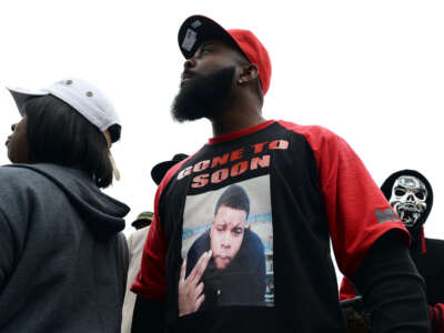 Michael Brown Sr., the father of 18-year-old Michael Brown who was shot dead by a police officer, speaks to neighbors as he distributes turkey for Thanksgiving where his son was killed in Ferguson, Missouri, on November 22, 2014.