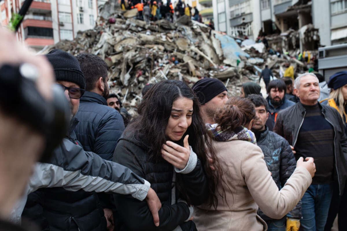 A woman reacts as rescuers search for survivors through the rubble of collapsed buildings in Adana, Turkey, on February 6, 2023, after a 7,8 magnitude earthquake struck the country's south-east.