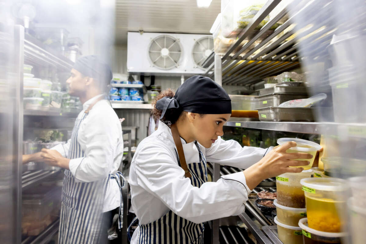 Restaurant workers sort through ingredients in pantry