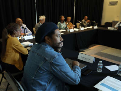 Dr. Jovan Lewis, center, listens during as the California Reparations Task Force meets to hear public input on reparations at the California Science Center in Los Angeles, California, on September 22, 2022.