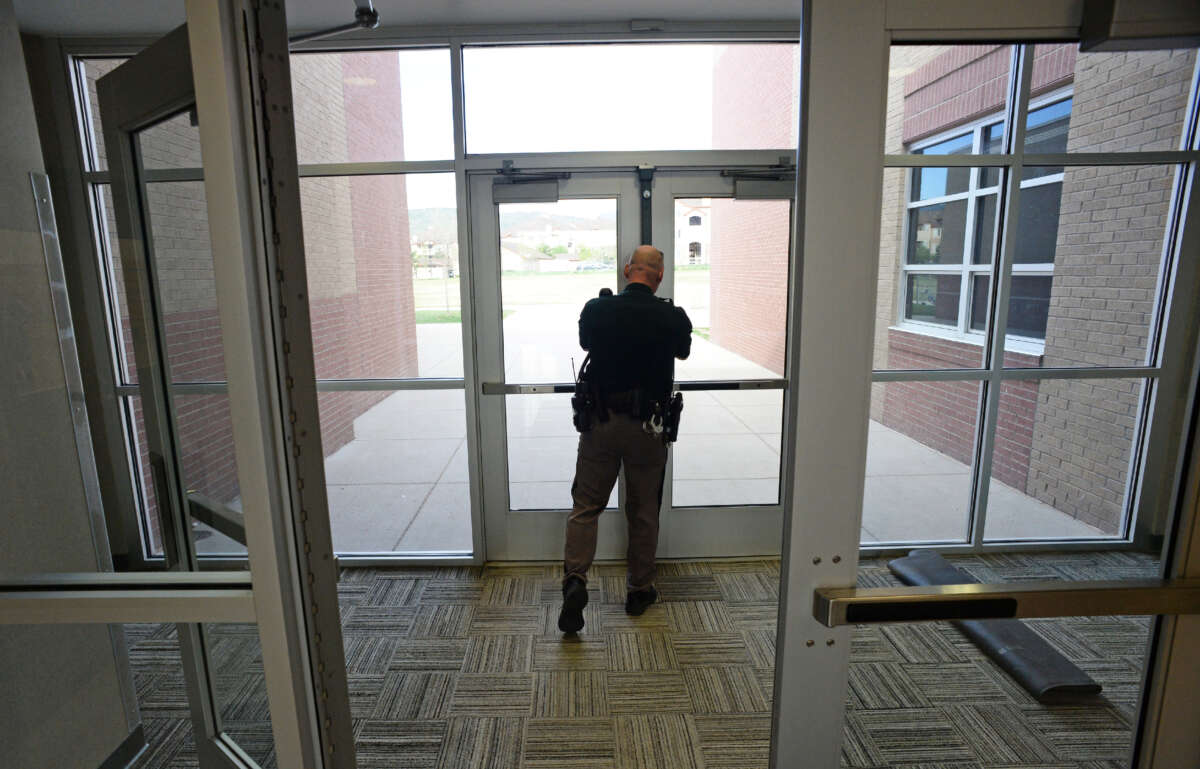 A school resource officer from the Jefferson County Sheriff's Department checks to make sure side doors are locked at Falcon Bluffs Middle School in Littleton, Colorado, on May 7, 2014.