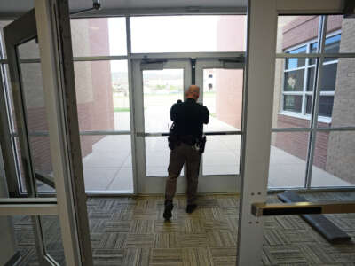 A school resource officer from the Jefferson County Sheriff's Department checks to make sure side doors are locked at Falcon Bluffs Middle School in Littleton, Colorado, on May 7, 2014.