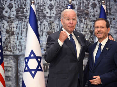 Joe Biden pumps his fist while embracing Israeli president Isaac Herzog