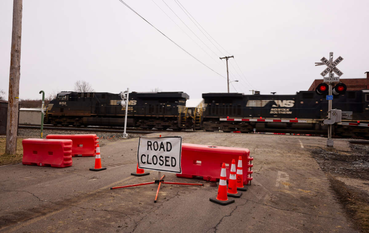 A Norfolk Southern train is en route near another train by the company which derailed, on February 14, 2023, in East Palestine, Ohio.