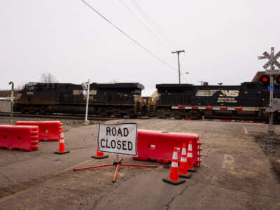 A Norfolk Southern train is en route near another train by the company which derailed, on February 14, 2023, in East Palestine, Ohio.