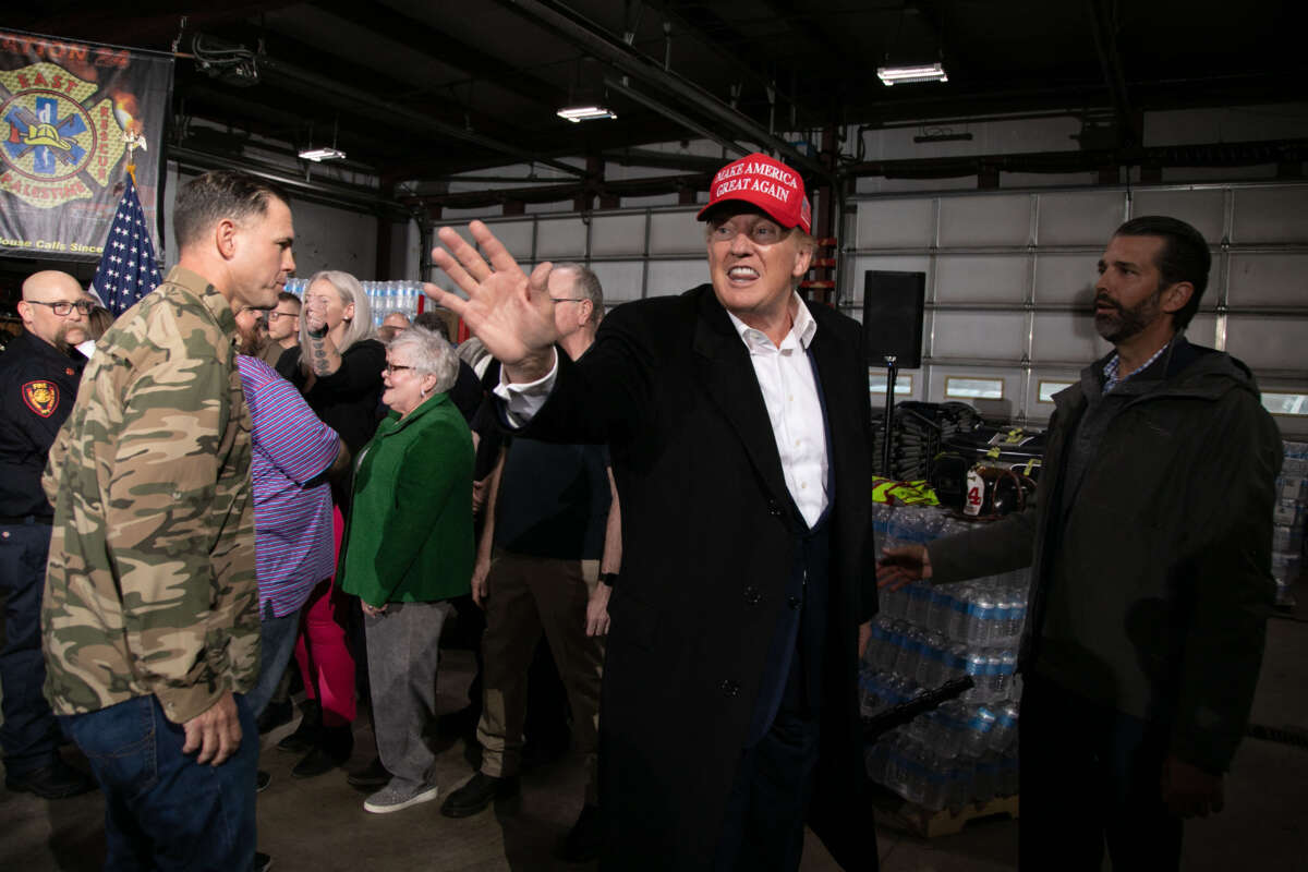 Donald Trump Jr., right, looks on as former President Donald Trump, center, waves while departing after an event at the East Palestine Fire Department in East Palestine, Ohio, on February 22, 2023.