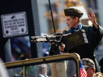 A child waves from the back of a jeep with an M60 during a Veterans Day parade in Reno, Nevada, on November 11, 2022.