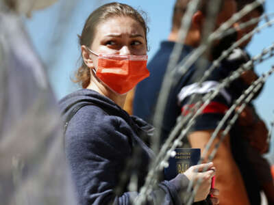 A person from Ukraine holds their Ukrainian passport before being allowed to cross the San Ysidro Port of Entry into the United States to seek asylum on March 22, 2022, in Tijuana, Mexico.