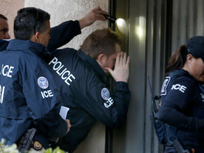 Immigration and Customs Enforcement agents from the Department of Homeland Security look into the window of an apartment while executing search warrants on March 3, 2015, in Rowland Heights, California.