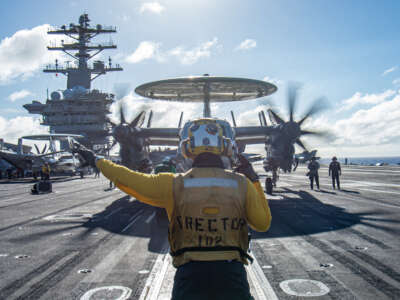 An E-2C Hawkeye prepares to launch from the flight deck of the aircraft carrier USS Nimitz to participate in a long-range maritime strike demonstration in the Philippine Sea on December 31, 2022.
