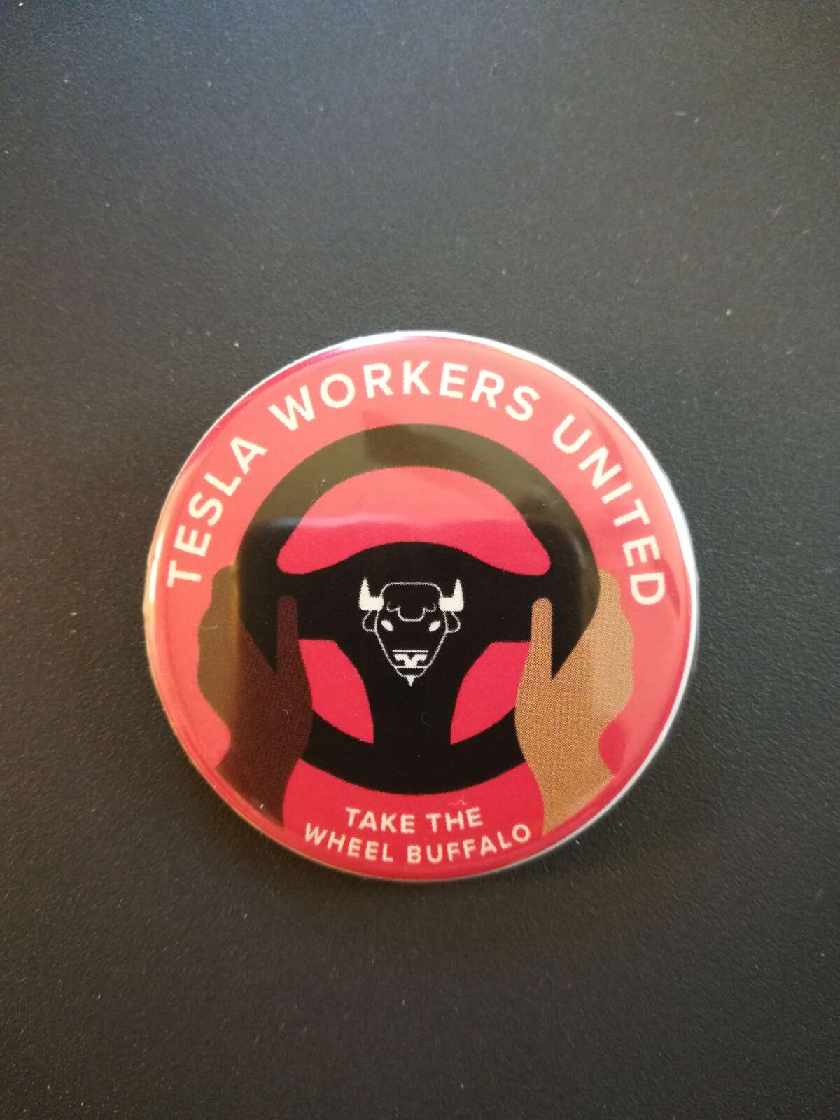 The campaign has distributed Tesla Workers United buttons such as these as part of the organizing effort.