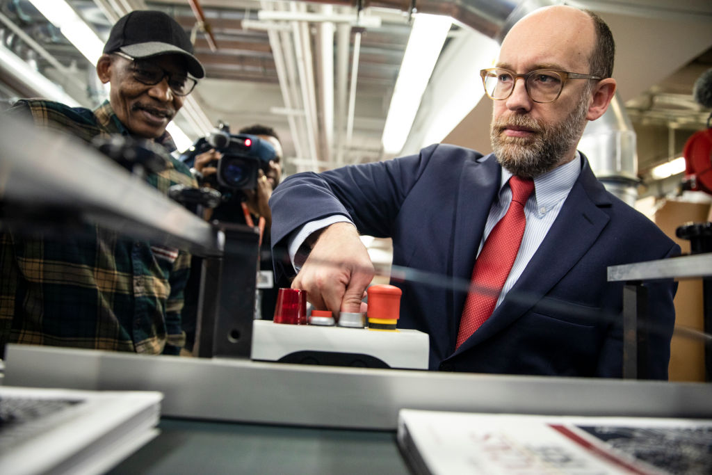 Acting Director of the Office of Management and Budget Russ Vought presses the button that starts the machine that will print copies of US President Donald Trump's proposed budget for the U.S. Government for the 2021 Fiscal Year on February 6, 2020, in Washington, D.C.