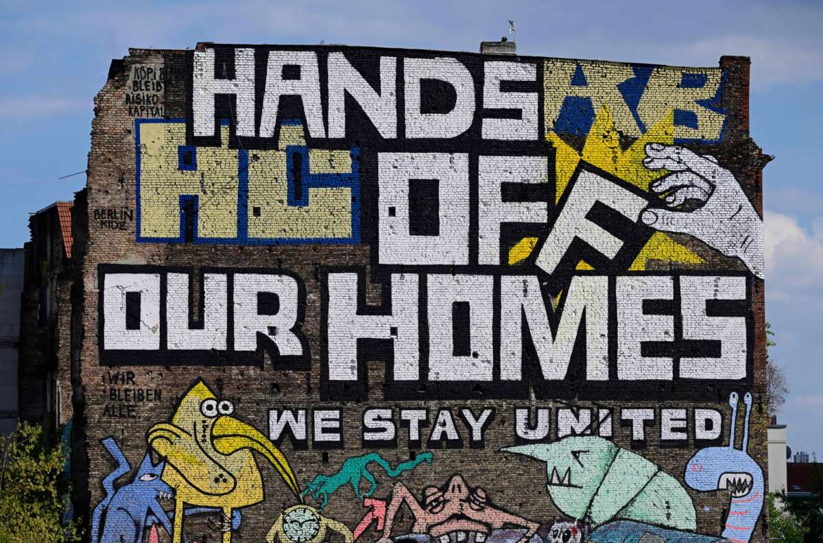 A giant mural reading "Hands off our homes" decorates one of Berlin's oldest alternative housing communities called Koepi, in Berlin, Germany on August 9, 2021.