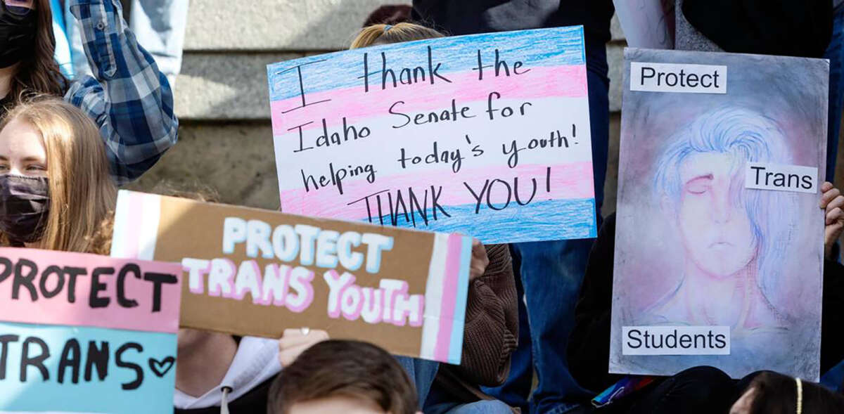 Transgender people and allies of trans youth hold signs at the Idaho Capitol at a celebration rally after the Senate killed a 2022 bill criminalizing gender-affirming care. The Idaho House voted February 14, 2023, to make providing this kind of care to children a felony.