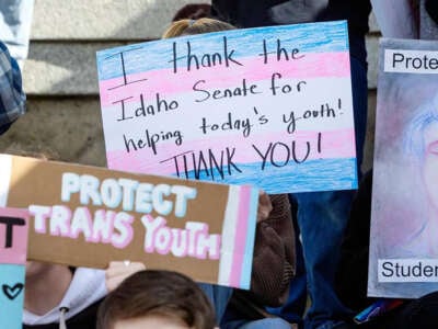 Transgender people and allies of trans youth hold signs at the Idaho Capitol at a celebration rally after the Senate killed a 2022 bill criminalizing gender-affirming care. The Idaho House voted February 14, 2023, to make providing this kind of care to children a felony.