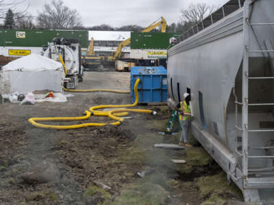 A worker cleans the inside of a train car near the derailment site in East Palestine, Ohio, on February 16, 2023.