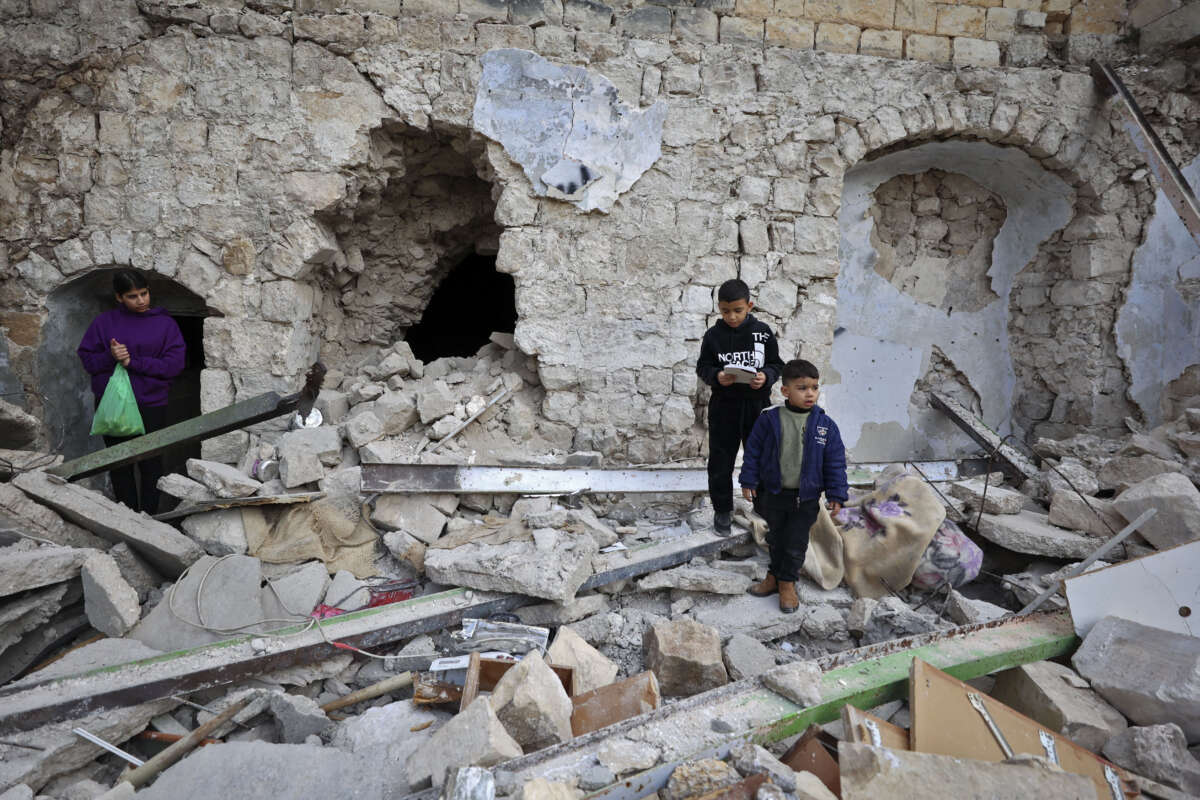 Children stand on the rubble of a house that was demolished during an Israeli army raid in the Old City of Nablus, on February 24, 2023.
