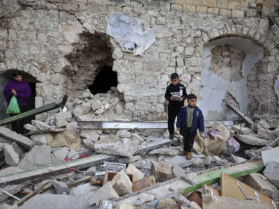 Children stand on the rubble of a house that was demolished during an Israeli army raid in the Old City of Nablus, on February 24, 2023.