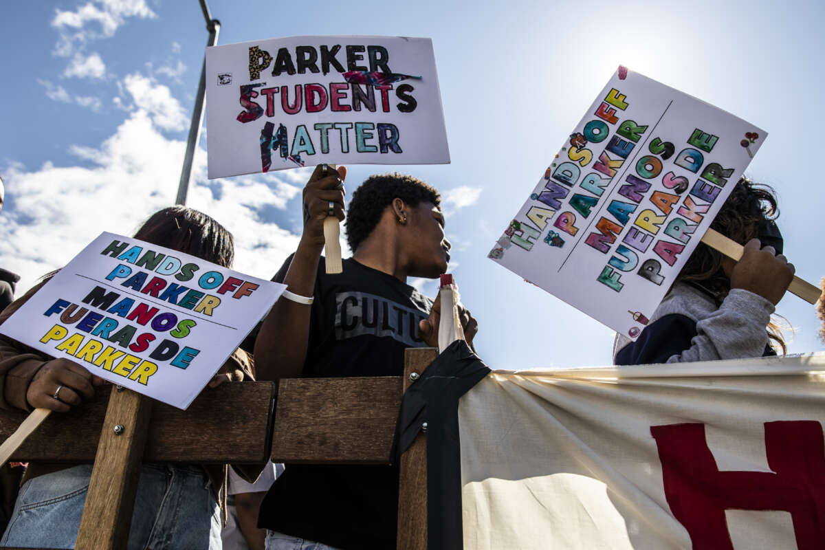 From left, Franci Garcia Dardon, Jayvien Bolden and Rosly Garcia hold signs during a protest against Oakland Unified School District's plan to close schools on March 5, 2022, in Oakland, California.