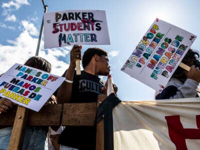 From left, Franci Garcia Dardon, Jayvien Bolden and Rosly Garcia hold signs during a protest against Oakland Unified School District's plan to close schools on March 5, 2022, in Oakland, California.