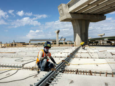 A worker welds rebar while constructing a new highway overpass