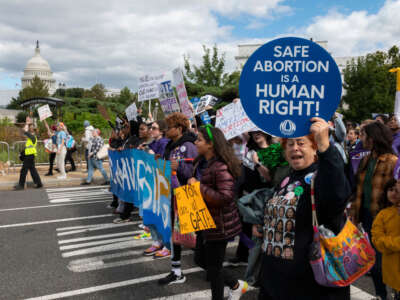 Demonstrators march past the U.S. Capitol during the annual Women's March in Washington, D.C., October 8, 2022.