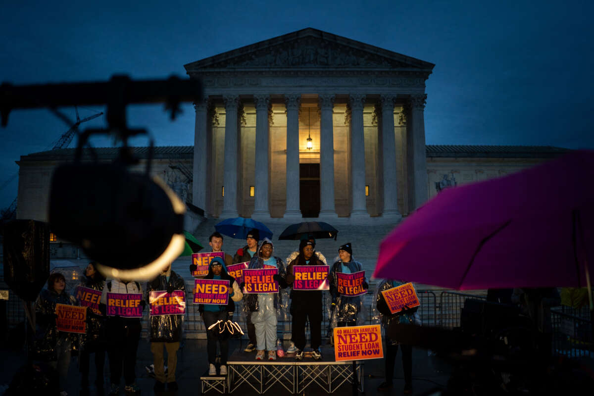 People rally in the rain to show support for the Biden administration's student debt relief plan in front of the the Supreme Court on February 27, 2023, in Washington, D.C.